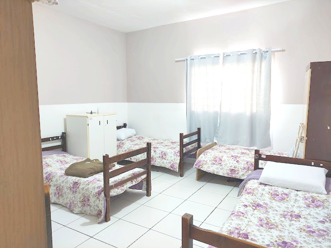 Quarto 1 da casa de repouso Lar Moreira com cama e iluminação natural